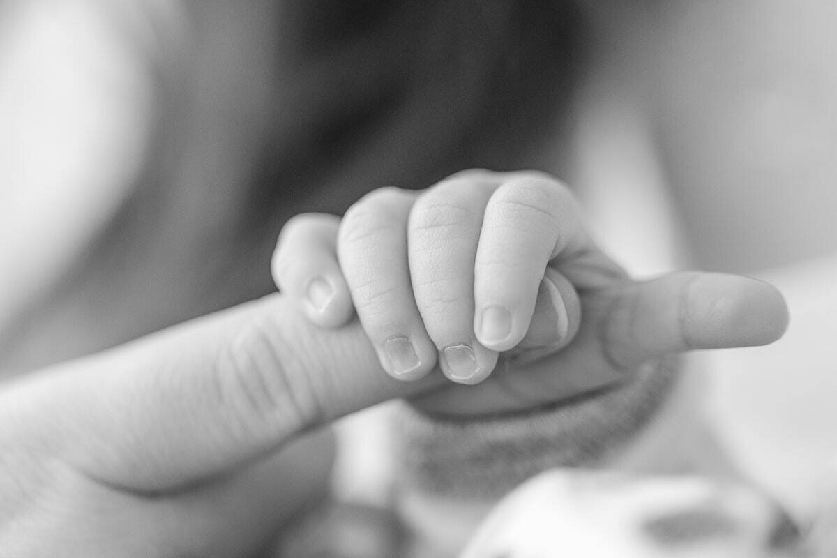 Baby grips mother's finger